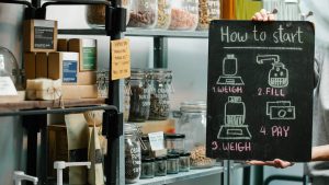 Assorted natural products and food in glass jars and paper packages on shelves in self service eco shop